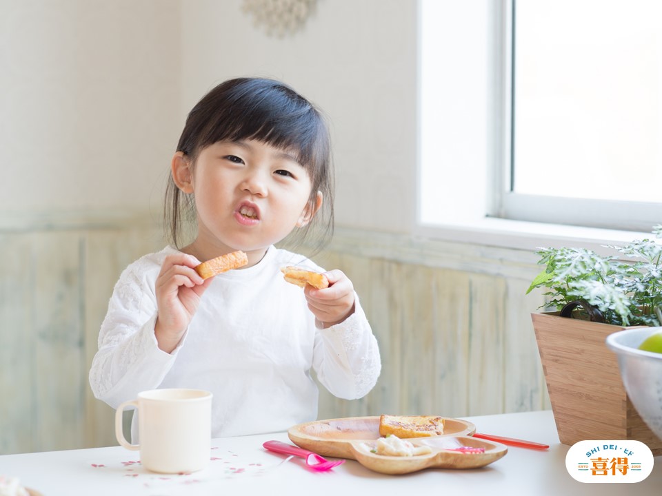 一個台灣的可愛小女生正在吃喜得炭火燒吐司圖片上有喜得炭火燒早午餐標誌