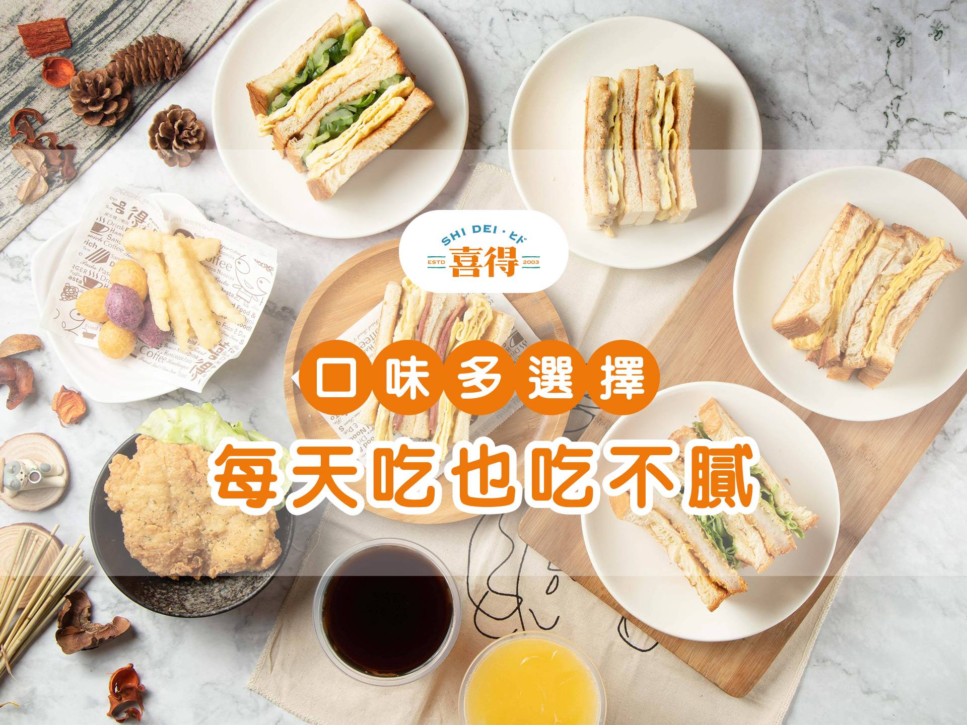 桌子上擺著喜得炭火燒三明治，還有地瓜黃金球，波浪薯條，古早味紅茶，柳橙汁。文字是口味多選擇，每天吃也吃不膩。